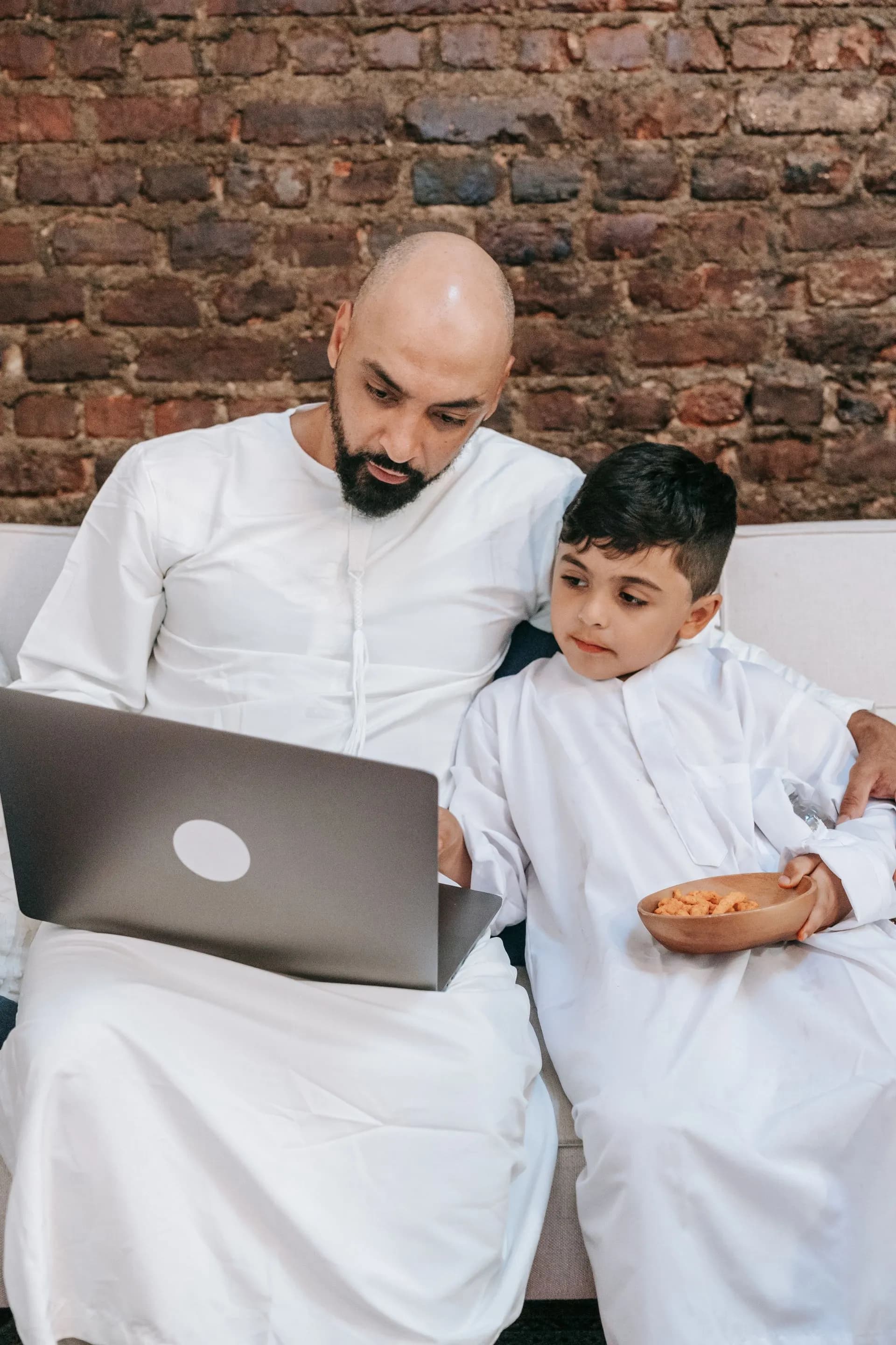 A father and son using a laptop together at home